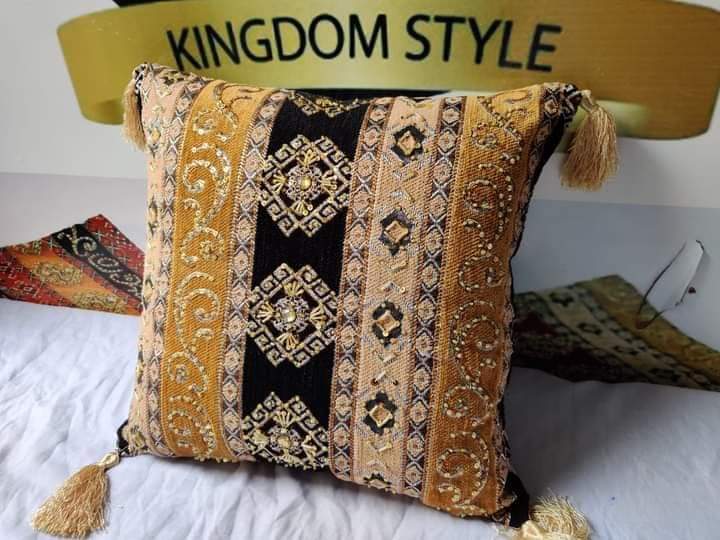 Hand-embroidered cushion covers with sequins, beads, gold ruffles, and tassels.