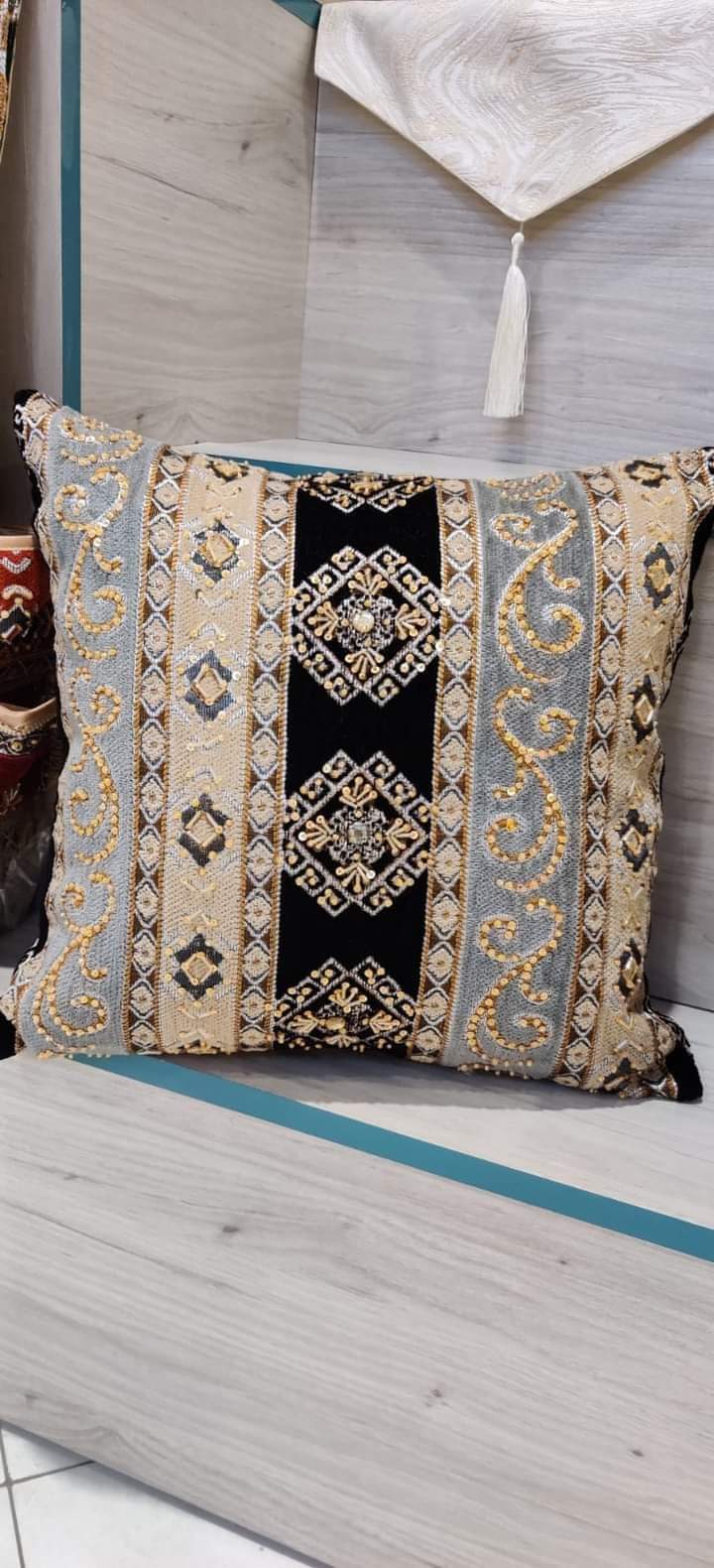 Hand-embroidered cushion covers with sequins, beads, gold ruffles, and tassels.