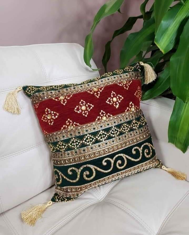 Hand-embroidered cushion covers with sequins, beads, gold ruffles, and tassels.