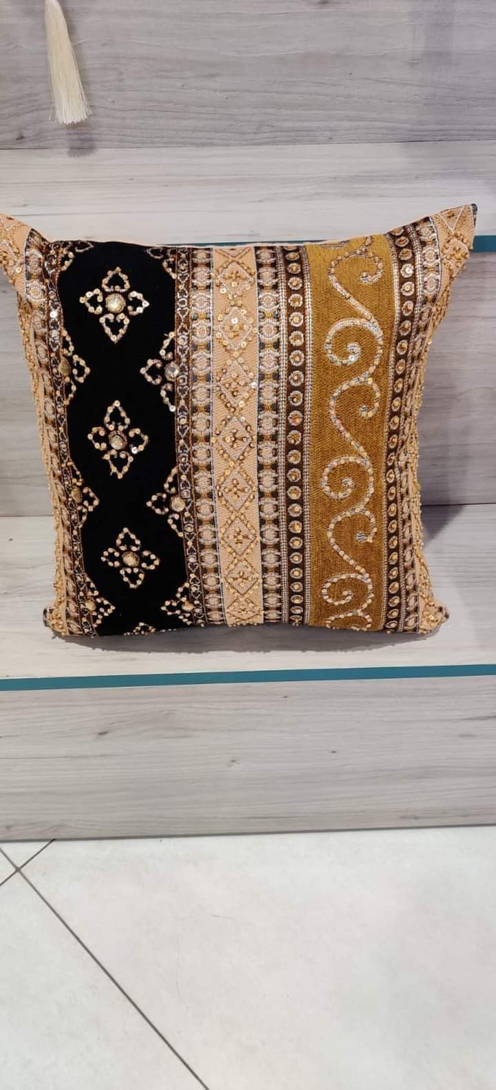 Hand-embroidered cushion covers with sequins, beads, gold ruffles, and tassels.