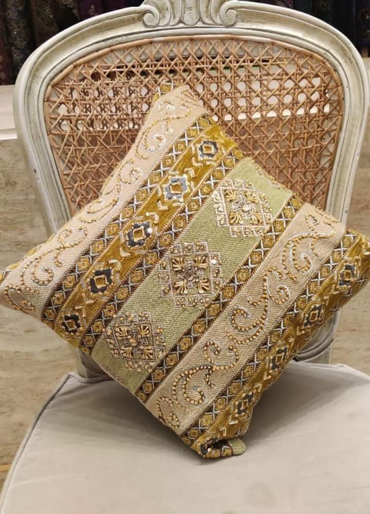 Hand-embroidered cushion covers with sequins, beads, gold ruffles, and tassels.