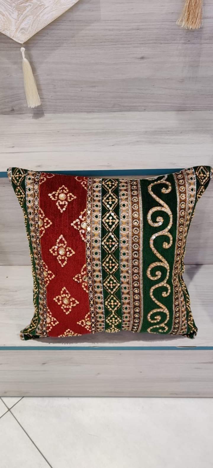 Hand-embroidered cushion covers with sequins, beads, gold ruffles, and tassels.