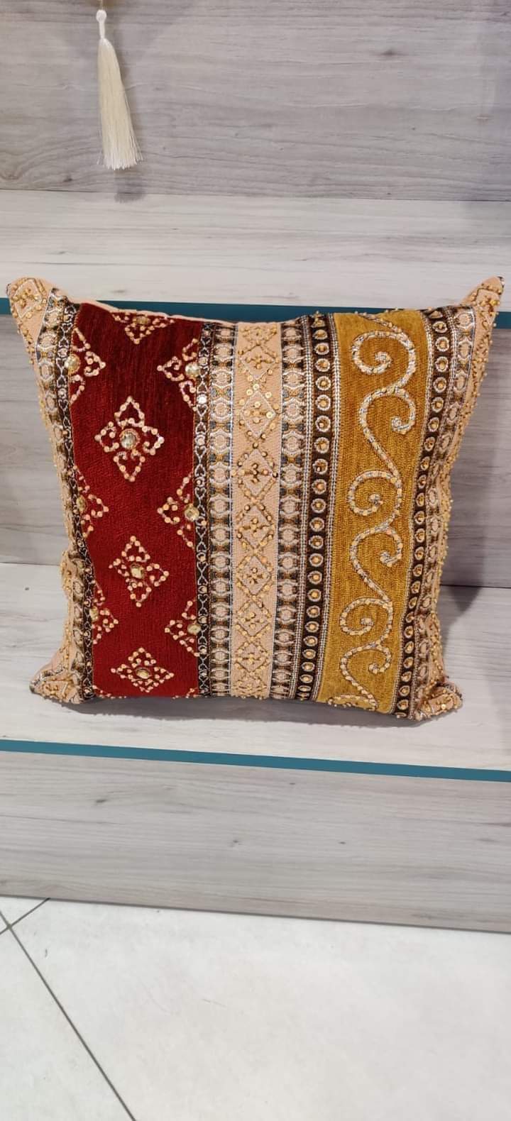 Hand-embroidered cushion covers with sequins, beads, gold ruffles, and tassels.