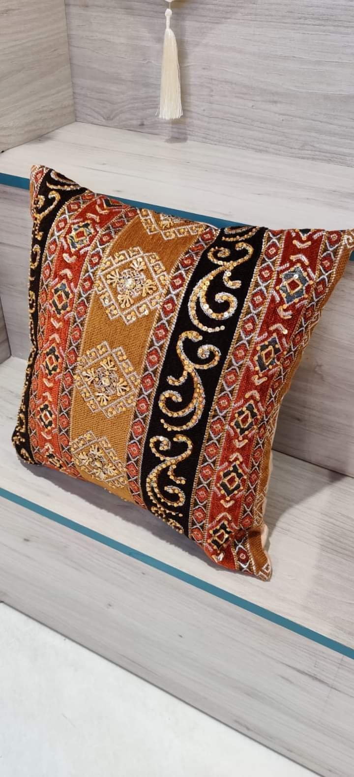 Hand-embroidered cushion covers with sequins, beads, gold ruffles, and tassels.